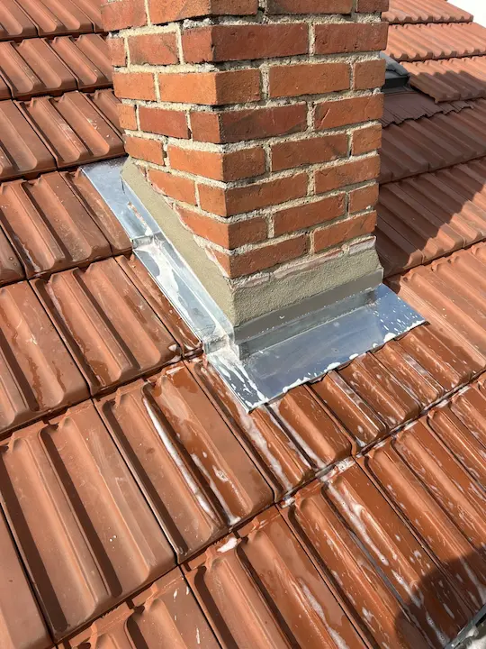 Reprise de la zinguerie d'une cheminée sur une toiture en tuiles, chantier M. Leger à Blois